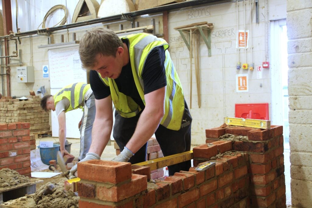 Student laying a brick