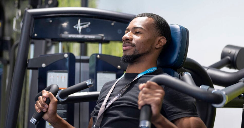 Male using weighted machine in gym